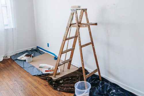 Wooden ladder set up indoors for painting preparations.