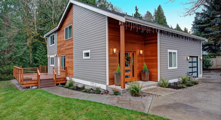 A modern two-story house with gray siding and a well-kept front yard.