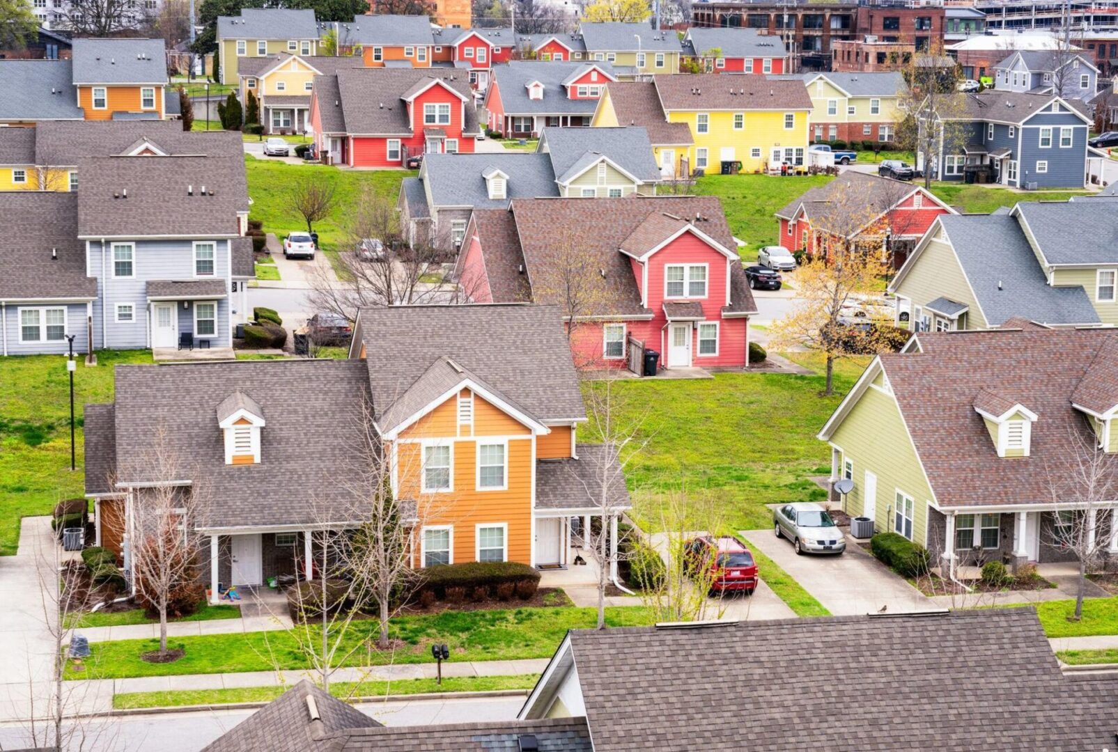 Colorful houses in a suburban neighborhood with well-kept lawns.