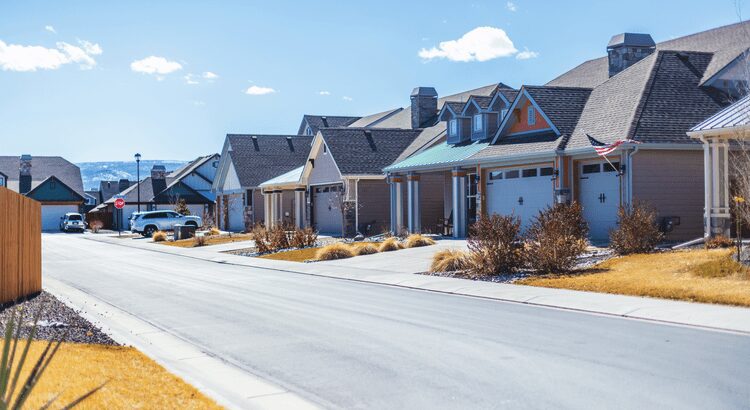 A row of suburban houses under a clear blue sky.
