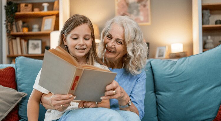 Grandmother and granddaughter reading a book together happily.
