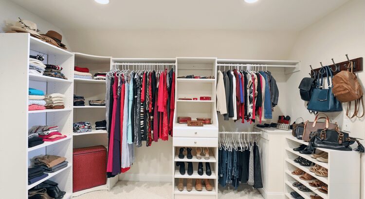 Organized walk-in closet with clothes, shoes, and accessories neatly arranged.