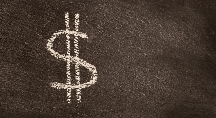 Dollar sign drawn with white chalk on a blackboard.