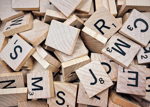 Scattered Scrabble tiles with letters and point values.
