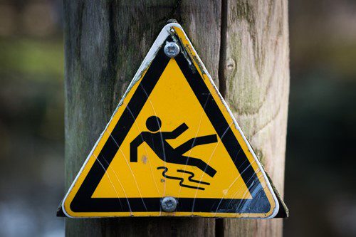 Warning sign indicating slippery surface ahead.