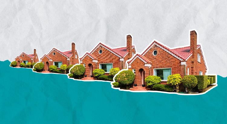 Row of charming brick houses with well-kept lawns under a clear sky.