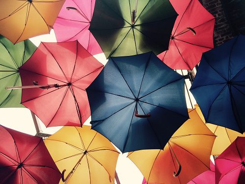 Colorful umbrellas viewed from below against the sky.