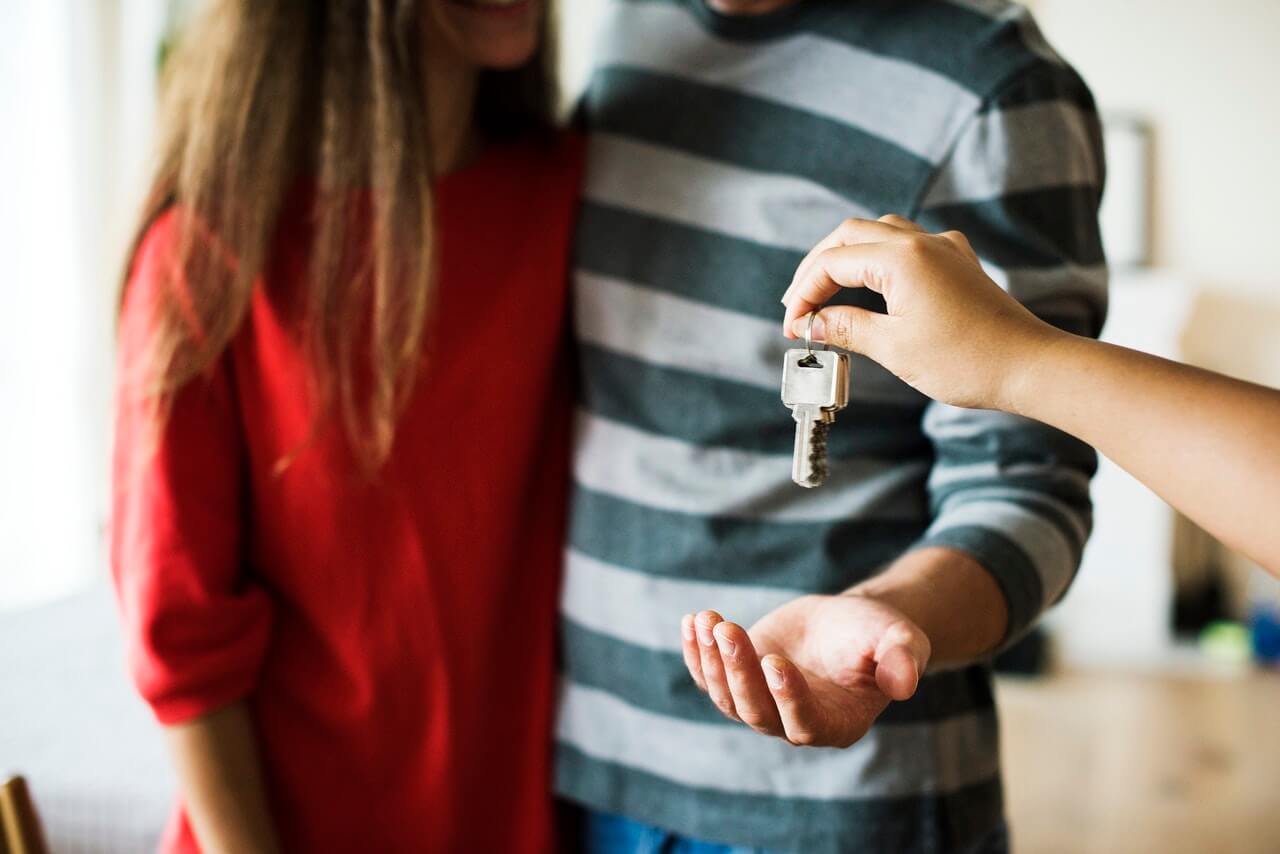 elevate-tips-buying A couple receiving house keys, symbolizing homeownership or moving in.