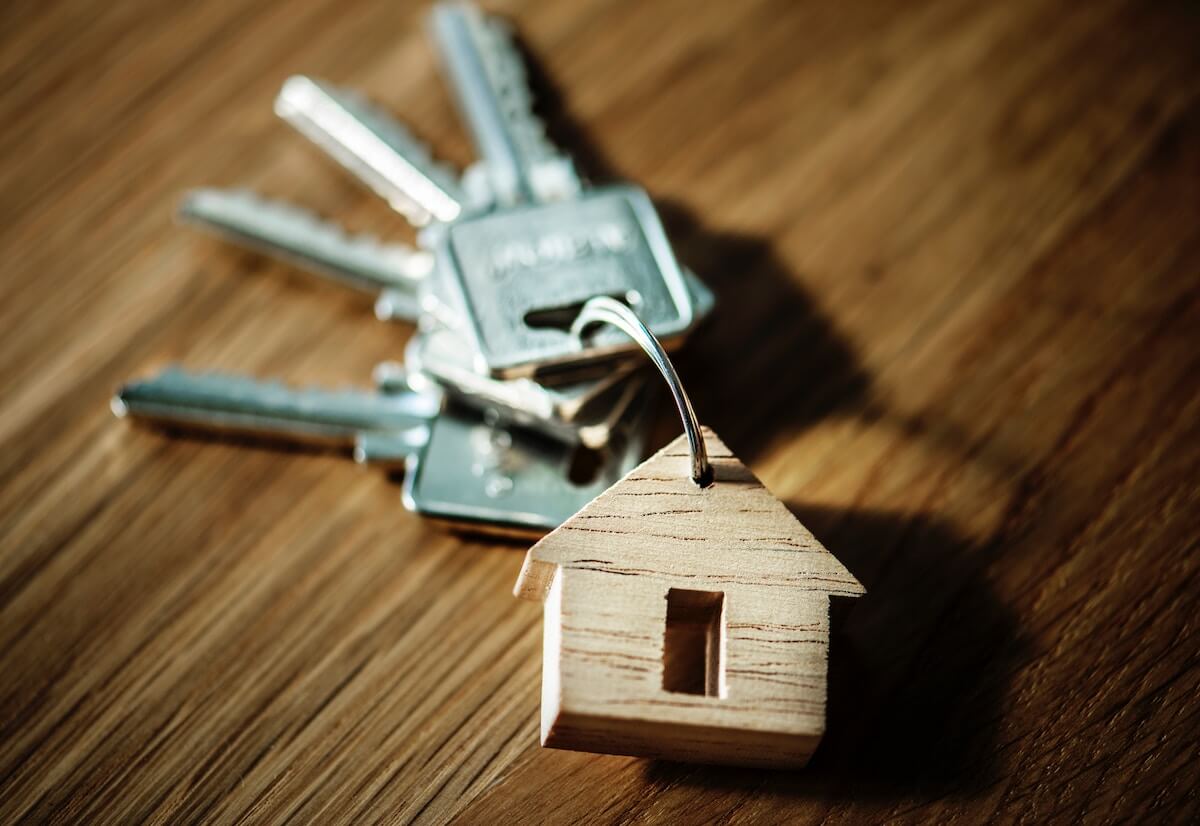 elevate-tips-mistakes A set of keys with a wooden house-shaped keychain on a wooden surface.