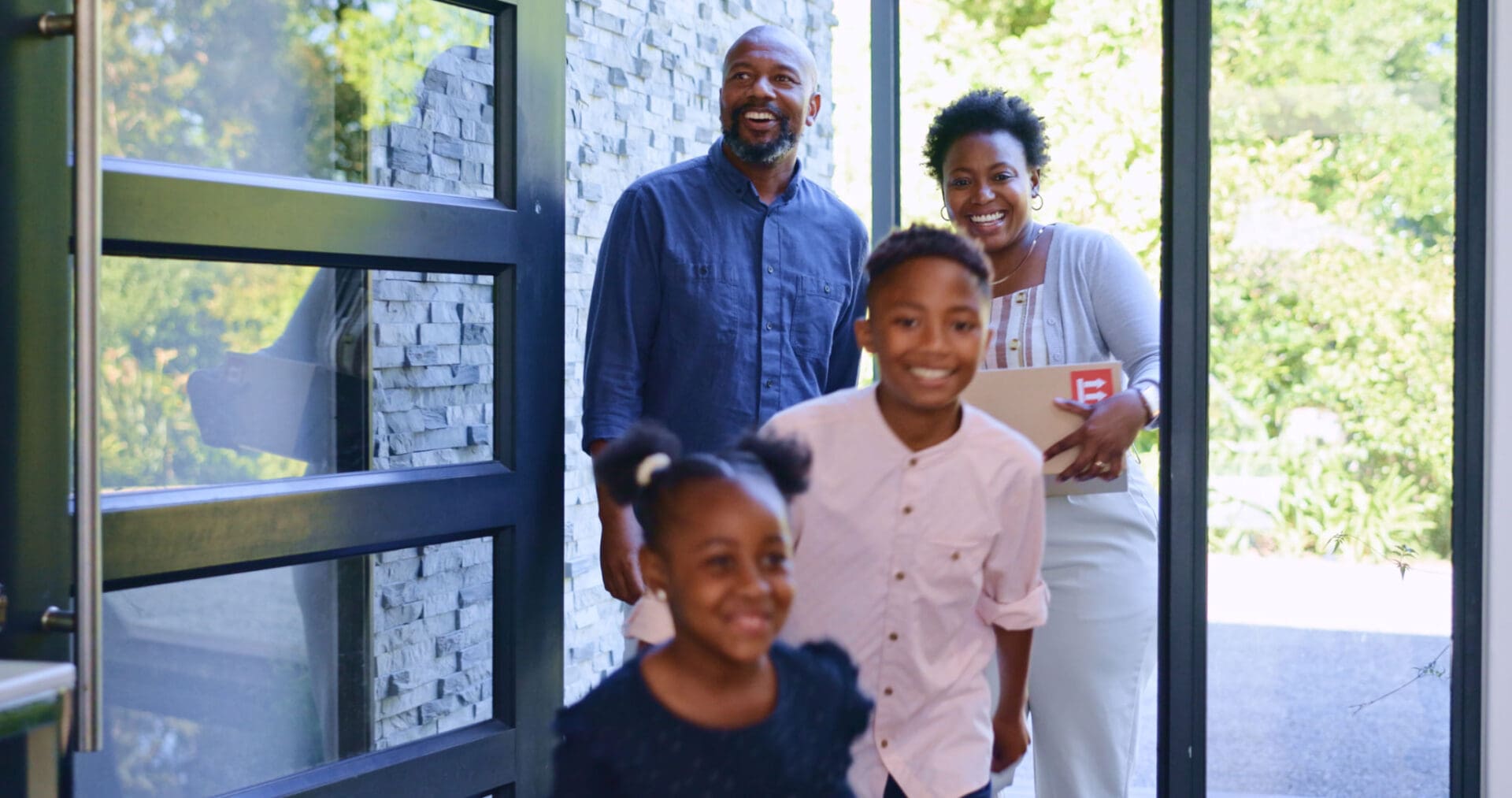 Smiling family happily entering their home together.